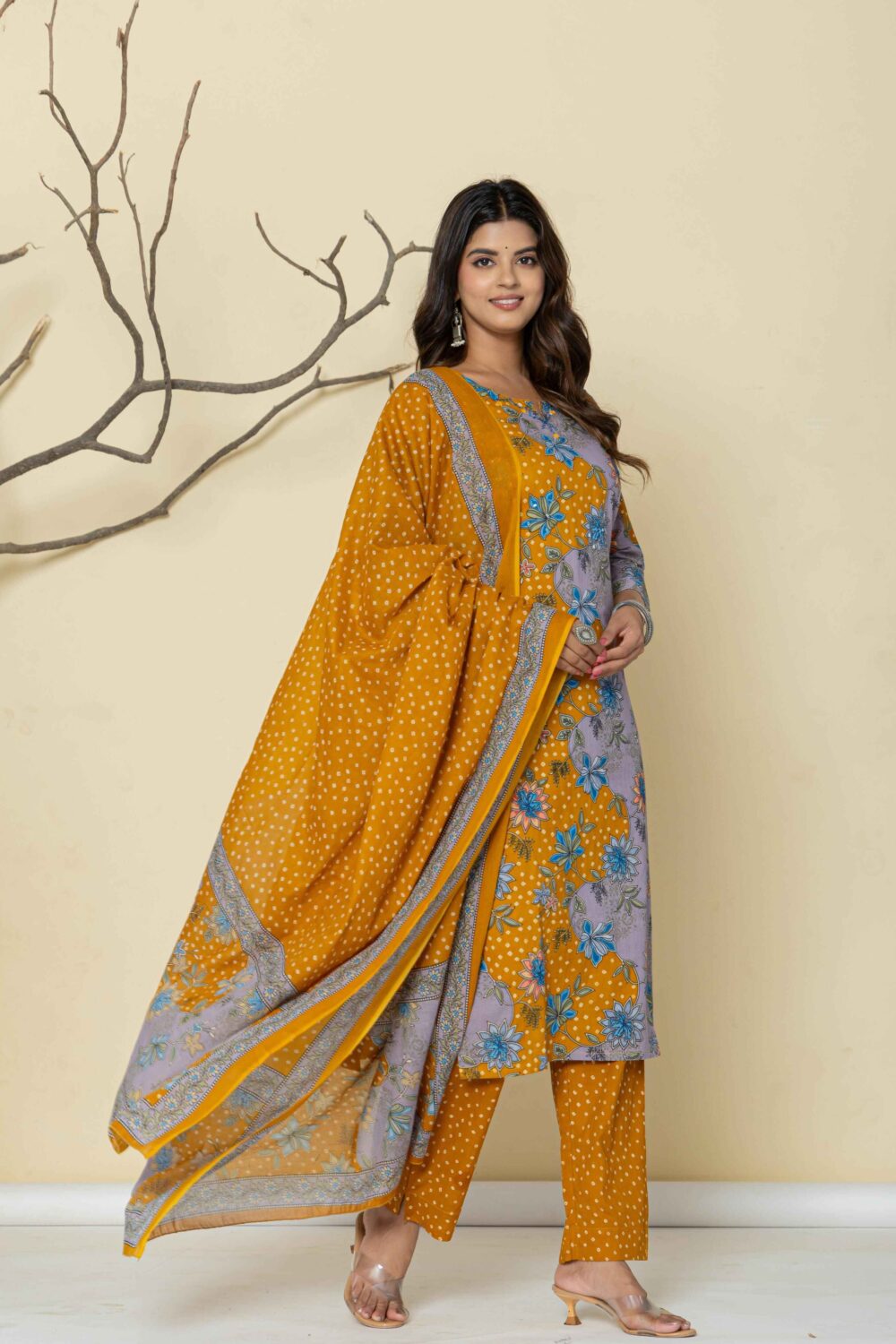 Woman wearing a mustard yellow printed kurti pant dupatta set