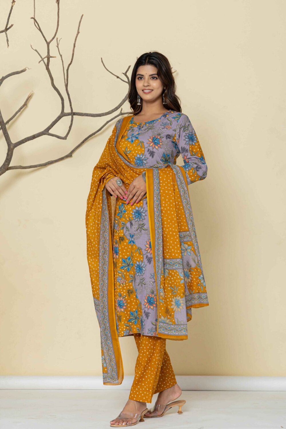 Woman wearing a mustard yellow printed kurti pant dupatta set with floral