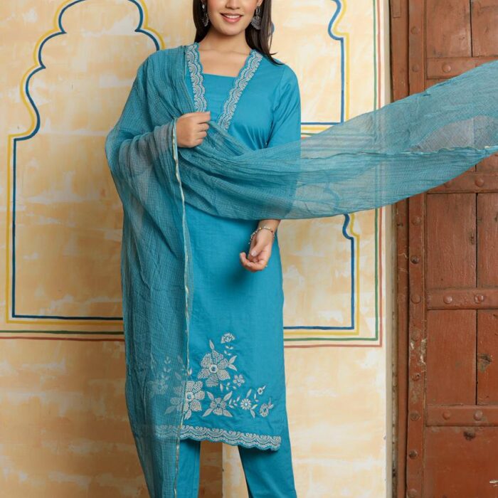 A woman posing in a teal blue ethnic suit with Kota Doria dupatta,