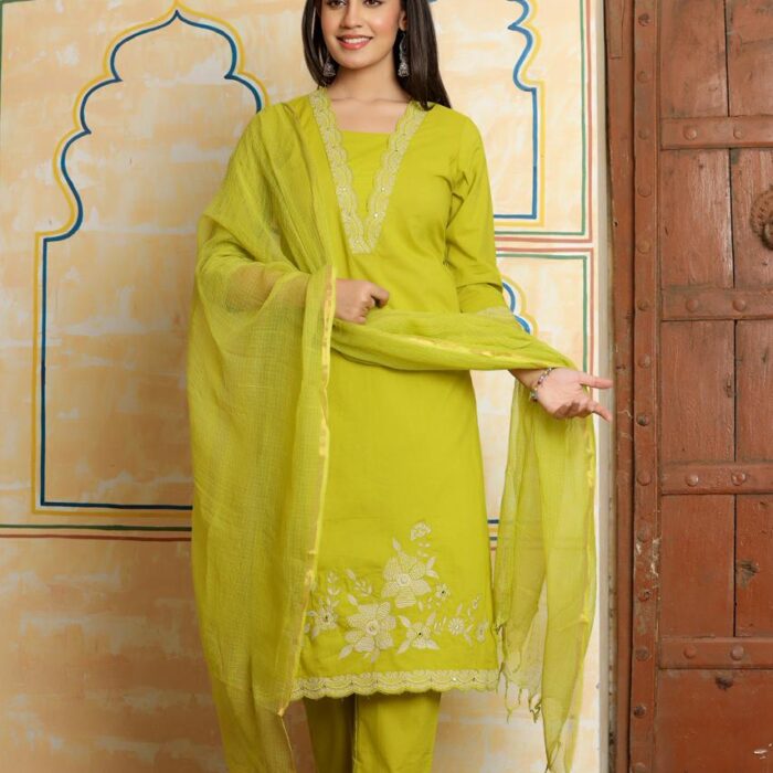 A woman posing in a vibrant lime green ethnic suit with a matching Kota Doria dupatta,