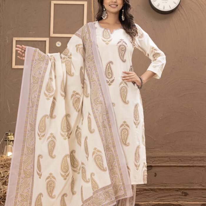 Women's cream paisley printed kurta set with matching striped pants and dupatta, styled in an elegant indoor rustic setting.