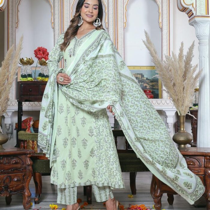 A female model wearing a mint green floral printed cotton A-line kurta with straight pants and a matching dupatta